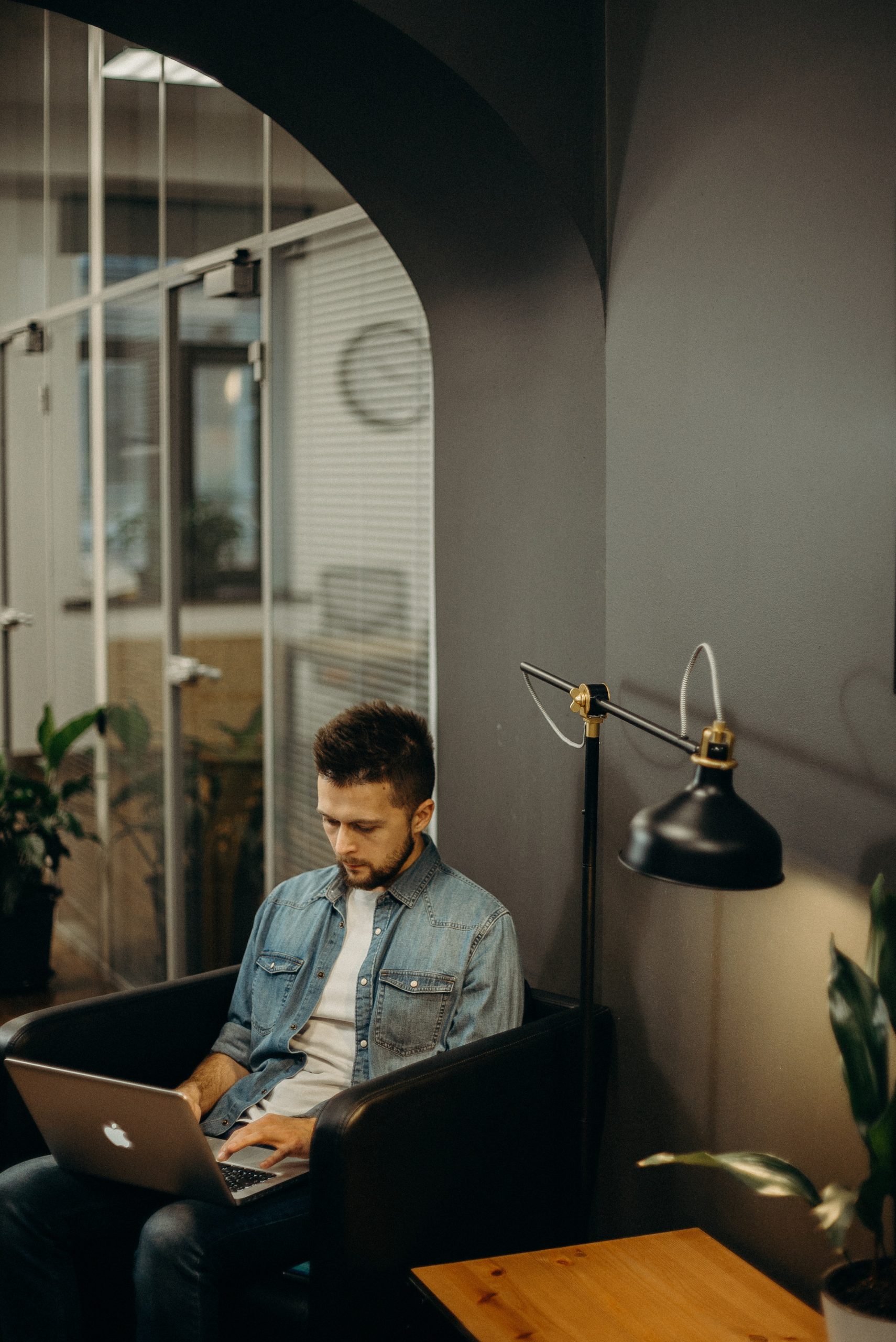 Man Using Macbook While Sitting on Sofa Chair